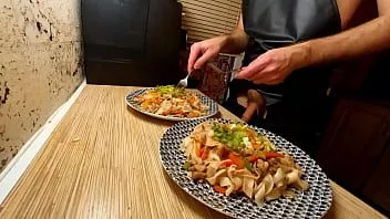 Reproduzir Cozinha sexy. chef gay nu está cozinhando macarrão de arroz com frango e legumes